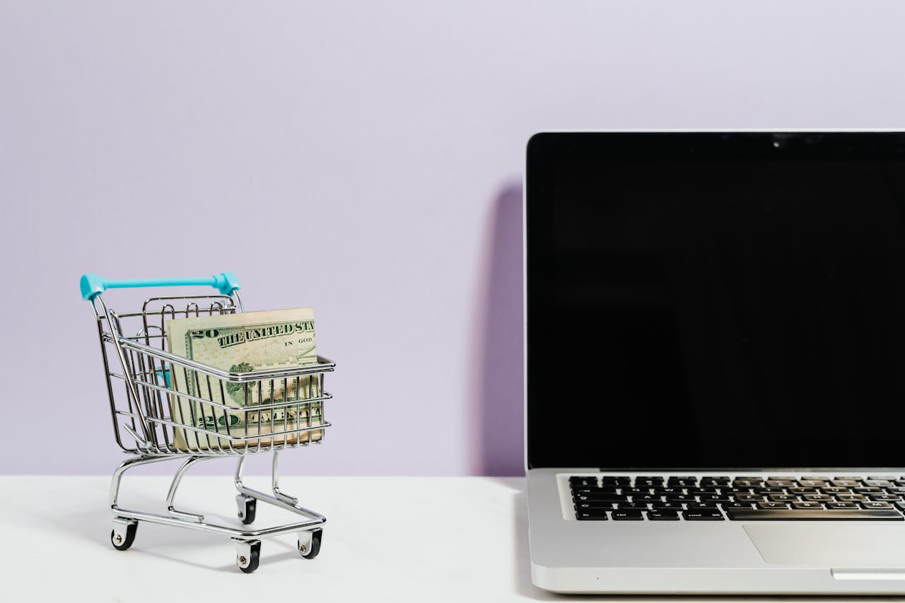 Crafting Captivating Headlines: Your awesome post title goes here Shopping cart with money next to a laptop symbolizing online shopping and e-commerce.
